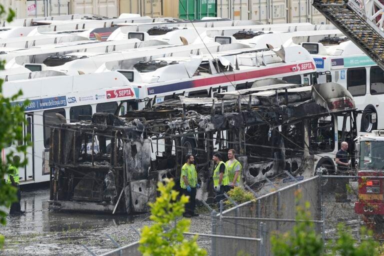 Officials looking at one of the burnt-out buses