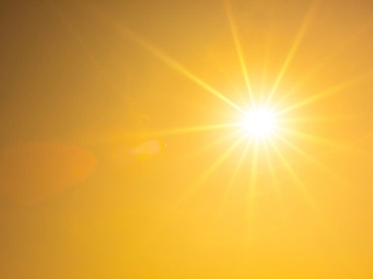 Summer background, orange sky with glowing sun