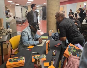 Tariq Trotter autographs his book at Community College of Philadelphia