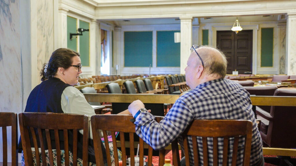 Two people sitting talking inside city hall