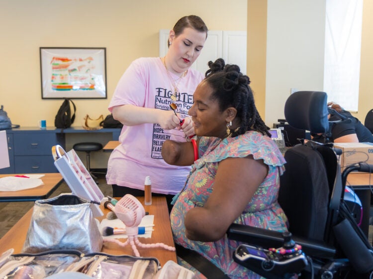 Rebecca Carpino (left) helps Candice Davis (right) align a makeup brush