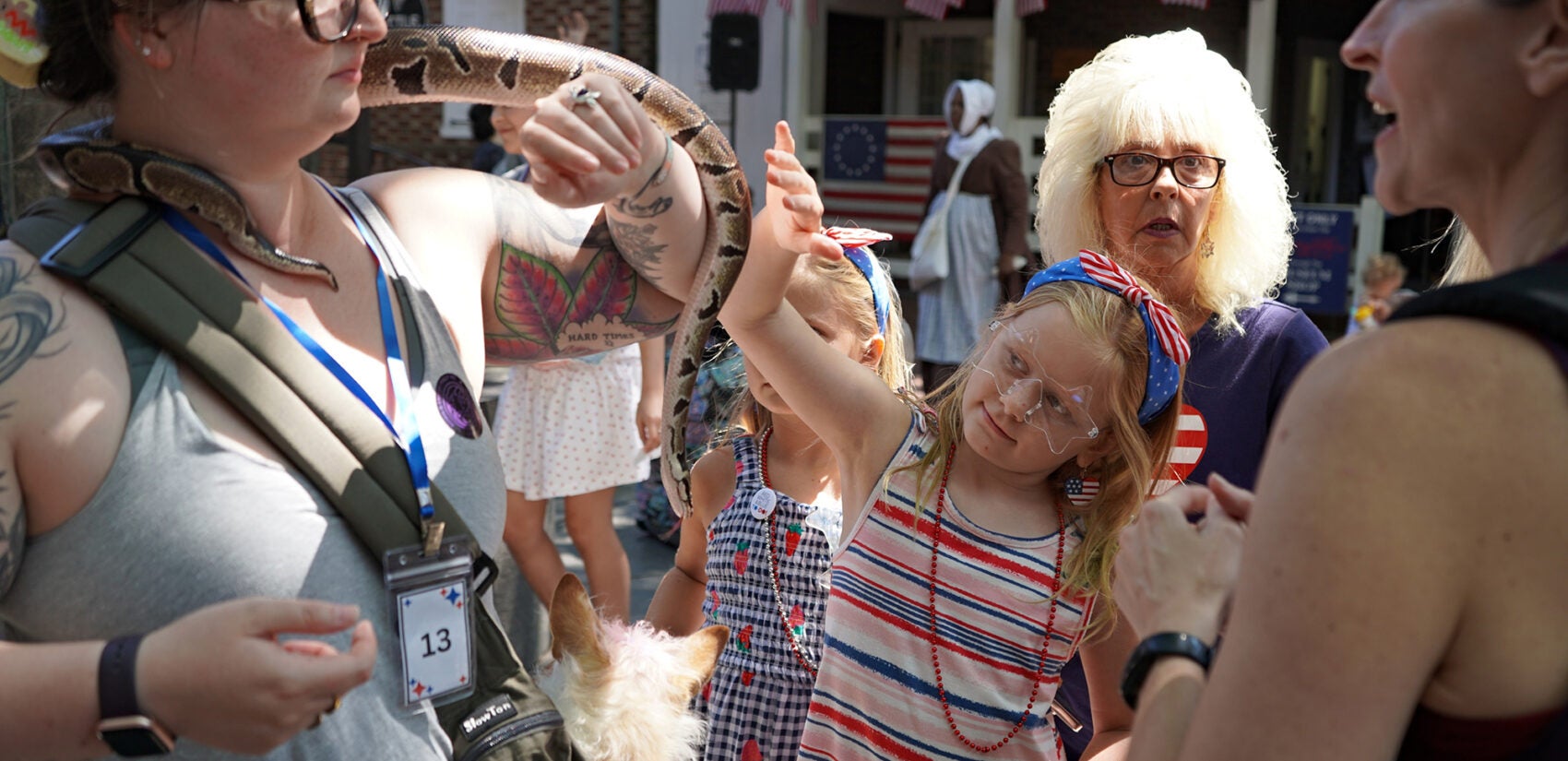 2025 07 04-n kariuki-betsy ross house pet parade wadsworth friends A child goes to pet a ball python on a woman's neck
