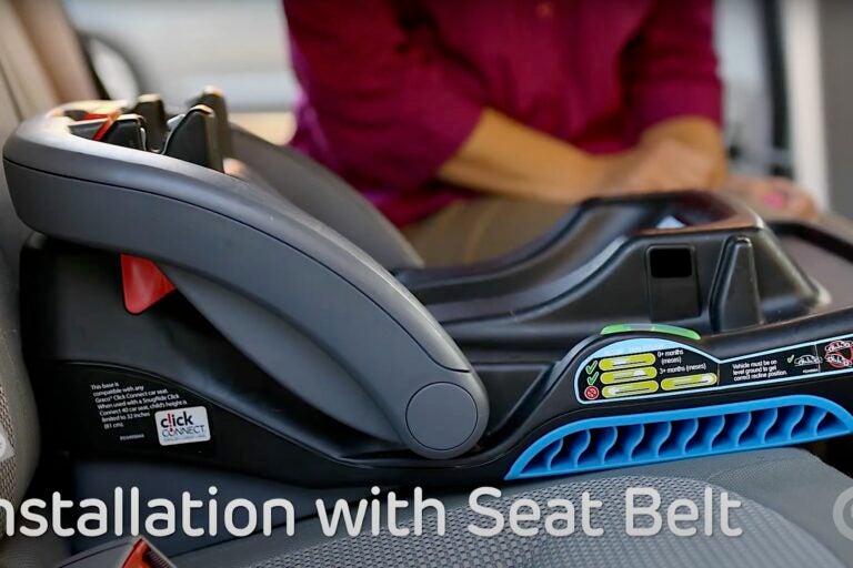 A close-up photo of someone installing a child seat