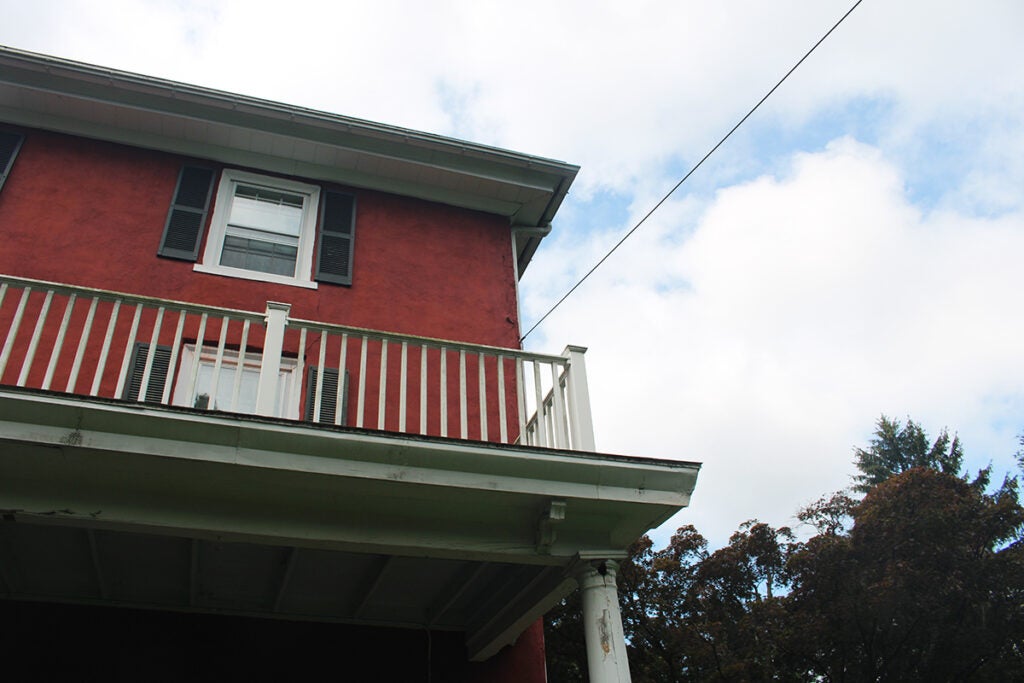 The balcony of a red house is shown