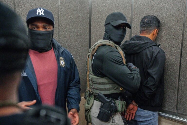 ICE-agents-immigration-2025-06-17 Immigration and Customs Enforcement agents escort a detained immigrant into an elevator