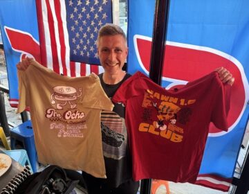 Max Stanford holds two shirts at Bar Jawn in Manayunk