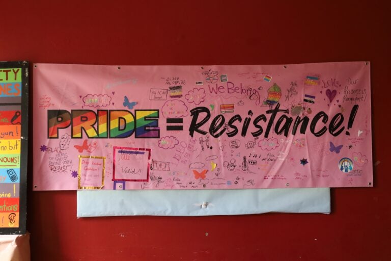 An art banner made by youth in the library at The Attic Youth Center reads PRIDE = RESISTANCE
