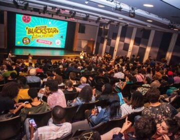 Audience members look towards a screen that says 