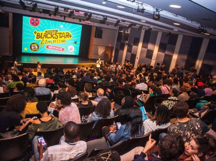 Audience members look towards a screen that says 