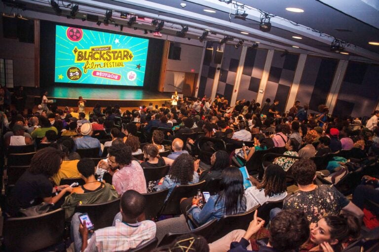 Audience members look towards a screen that says 
