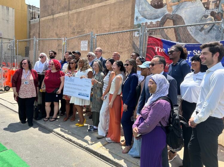 Representatives from community development corporations gold a check