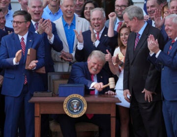 Donald Trump signs his spending bill in front of Republican legislators