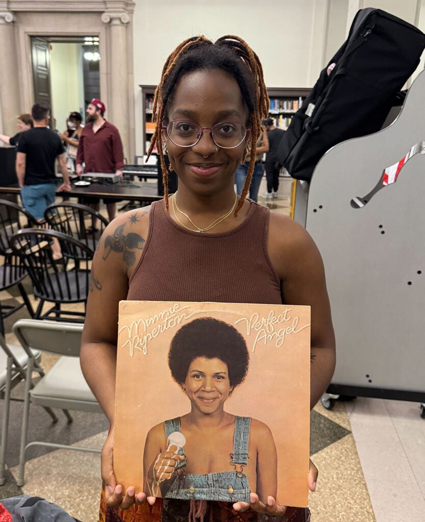 A woman holds a vinyl record of "Perfect Angel" by singer Minnie Riperton