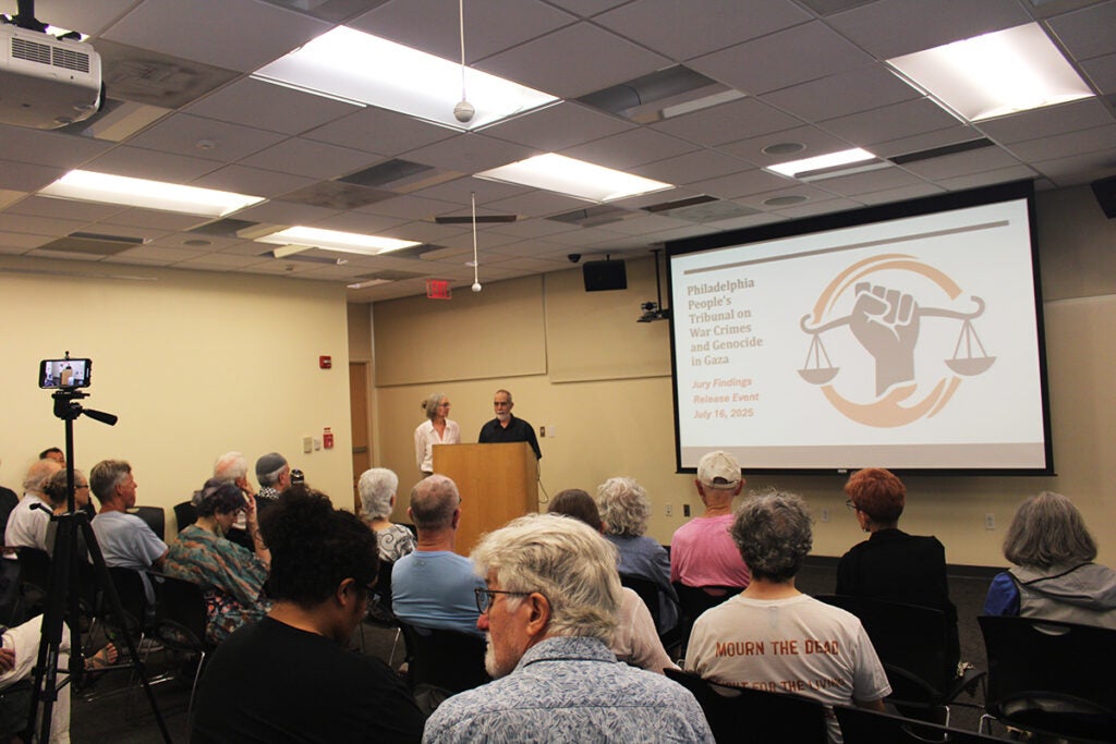 An audience sits in a room discussing The People's Tribunal on War Crimes and Genocide in Gaza