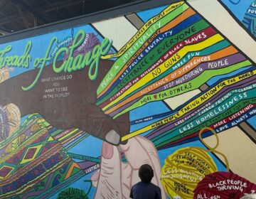 A child looks at a mural at 2025's Latino Arts and Film Festival
