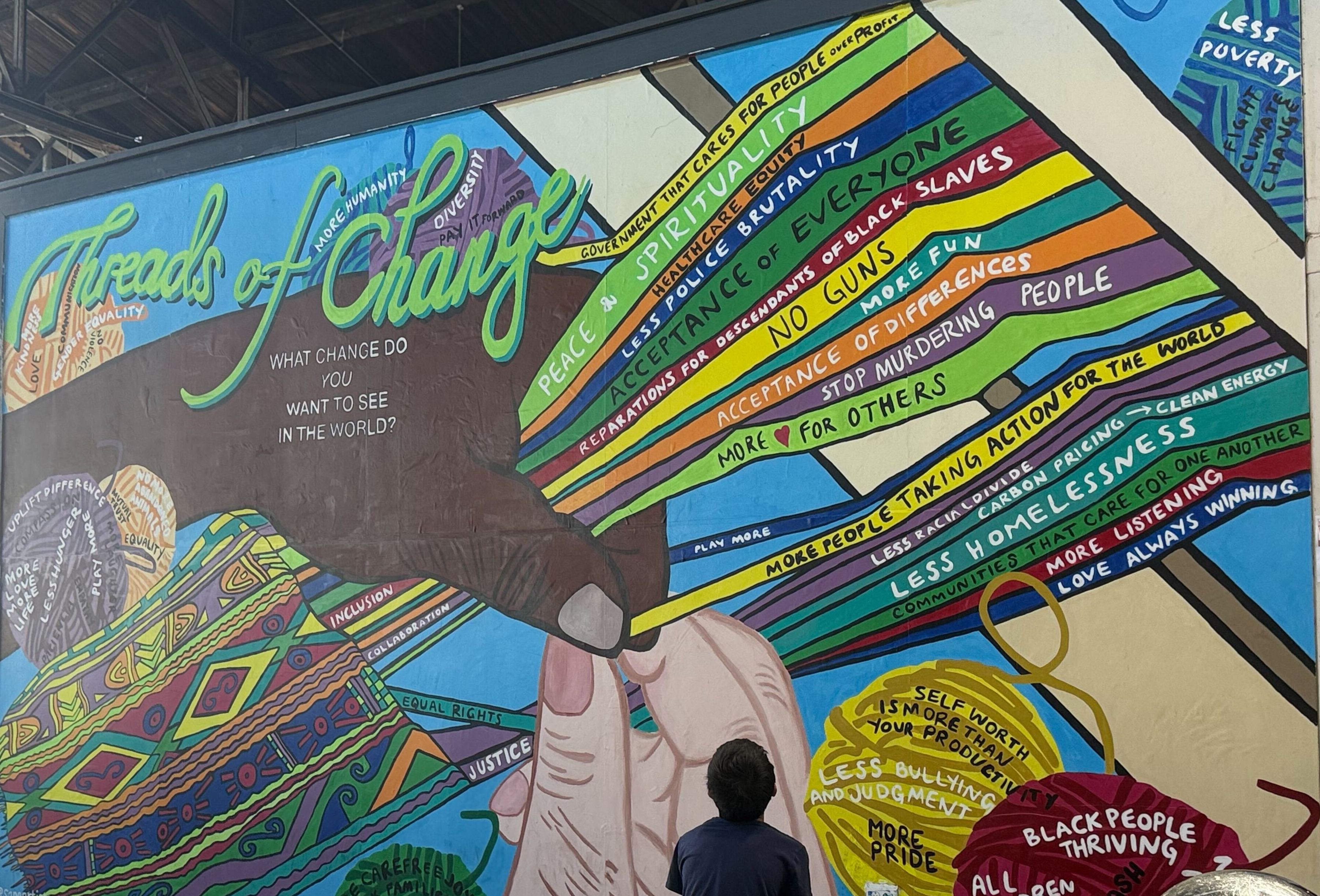 A child looks at a mural at 2025's Latino Arts and Film Festival