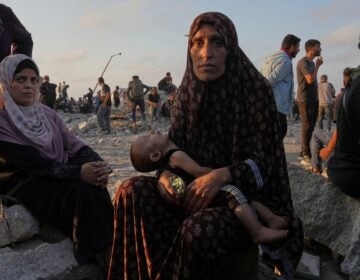 Somoud Wahdan looks at the camera as she sits with her child