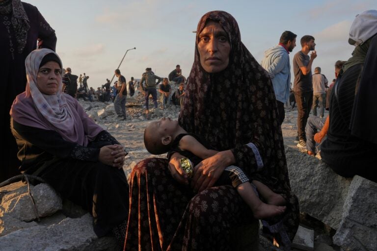 Somoud Wahdan looks at the camera as she sits with her child
