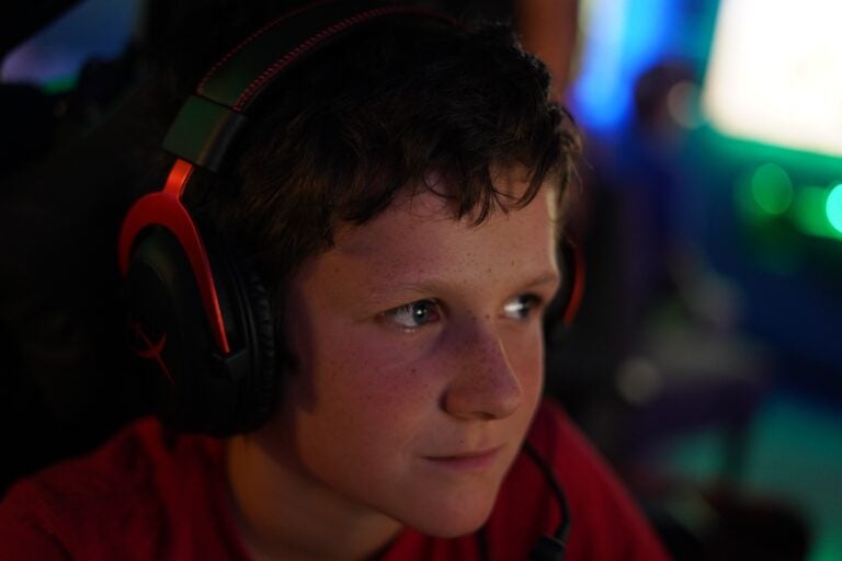 oscar-lasko-ymca-k-cooper-2025-07-16-1 A boy wearing headphones watches his video game intently