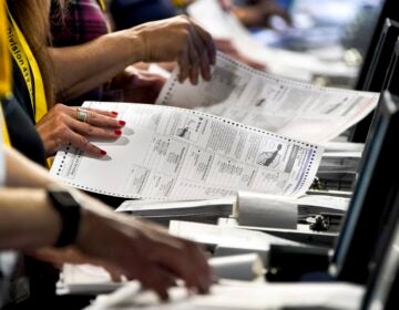 Election workers perform a recount of ballots