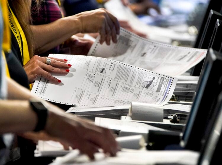 Election workers perform a recount of ballots