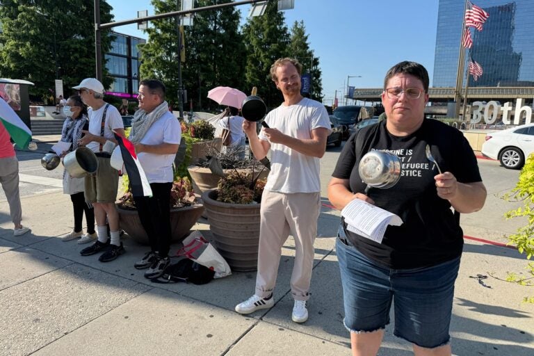 People holding pots and signs outside 30th Street Station