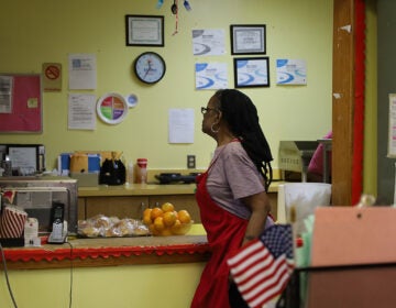 A woman helps kitchen staff at a senior community center