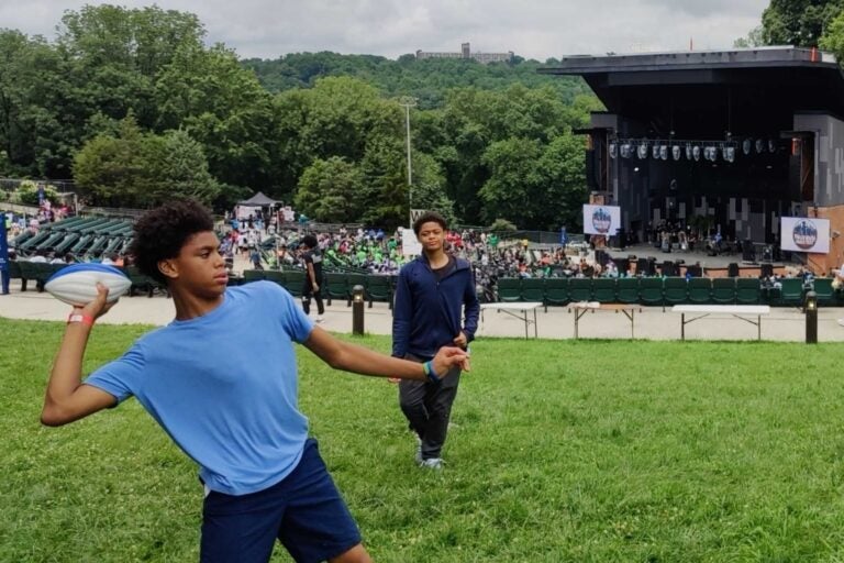 Teenagers throw around a football at Philly Youth Music Fest 2025