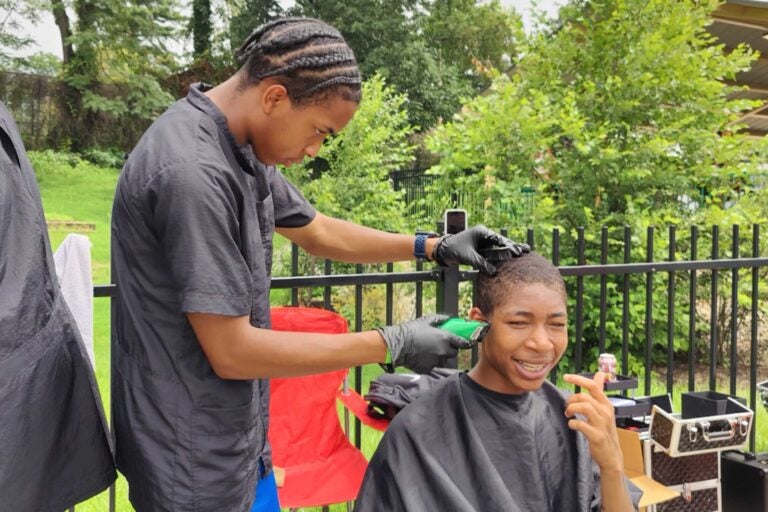 a barber gives a haircut at Philly Youth Music Fest 2025