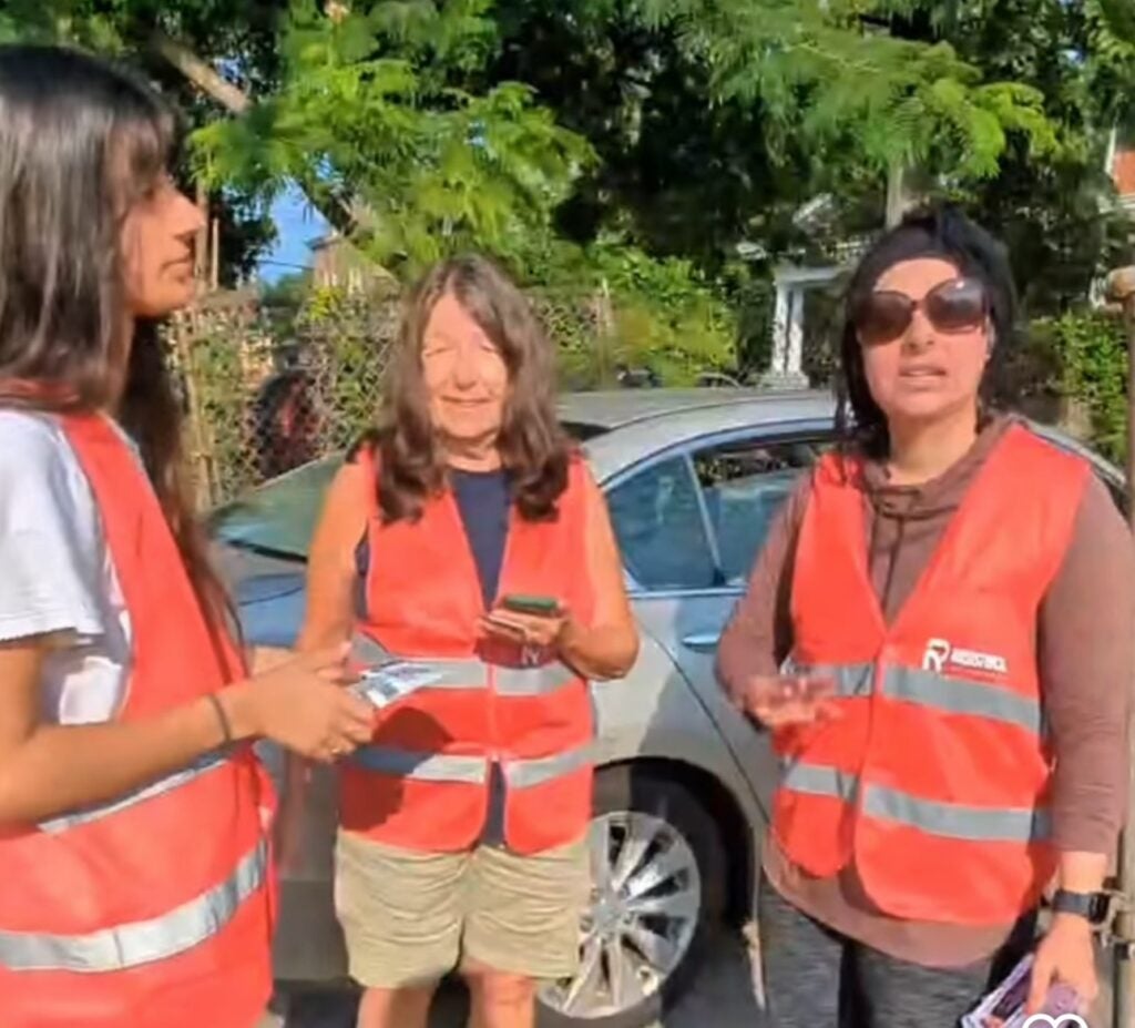 Three women wearing orange vests