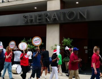 Protesters march in front of the entrance to the Sheraton hotel