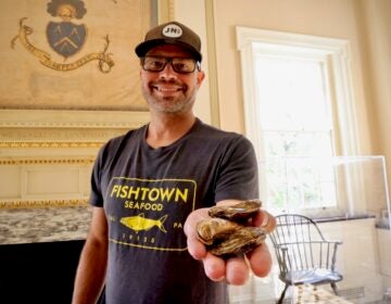 Bryan Szeliga holding three oysters