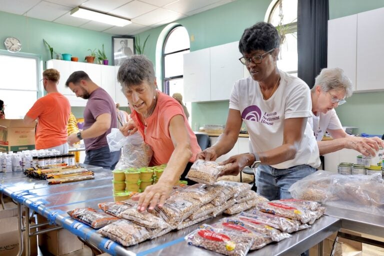 Food pantry volunteers organize food giveaway tables at Lutheran Settlement House