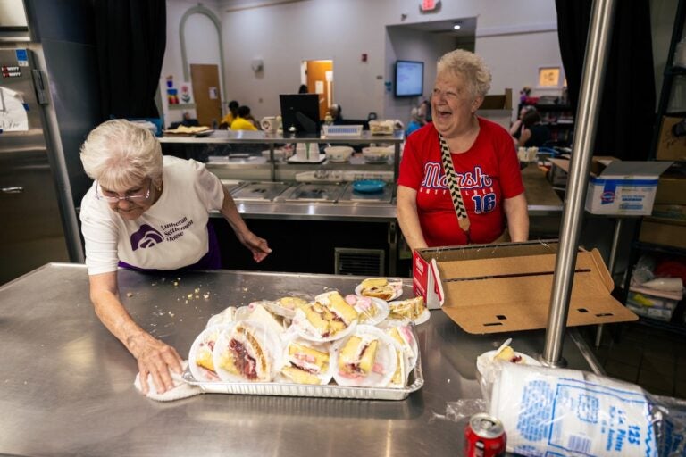 Marge Wible (left) and Kathy McGovern (right) cut and wrap cake slices