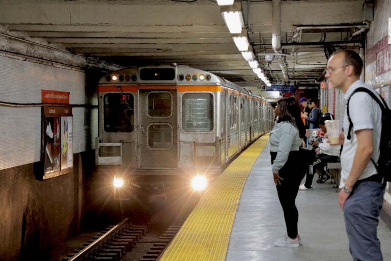 People waiting on a platform as a subway train approaches