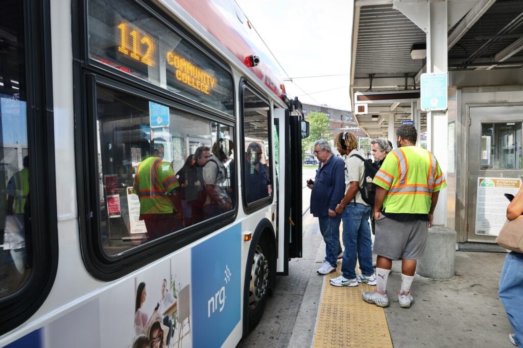 People lining up to board a bus