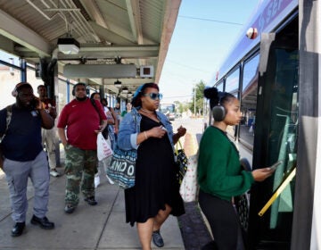 A group of people line up to get onto a SEPTA bus