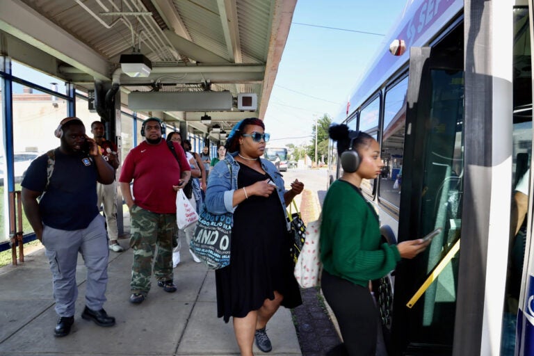 A group of people line up to get onto a SEPTA bus