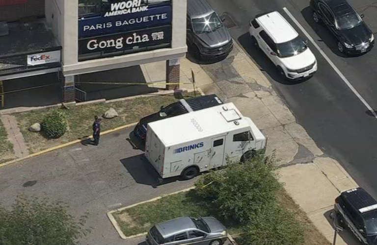 An armored truck in a shopping center parking lot