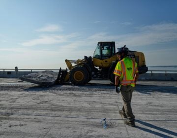 A demolition crew member walking toward a bulldozer
