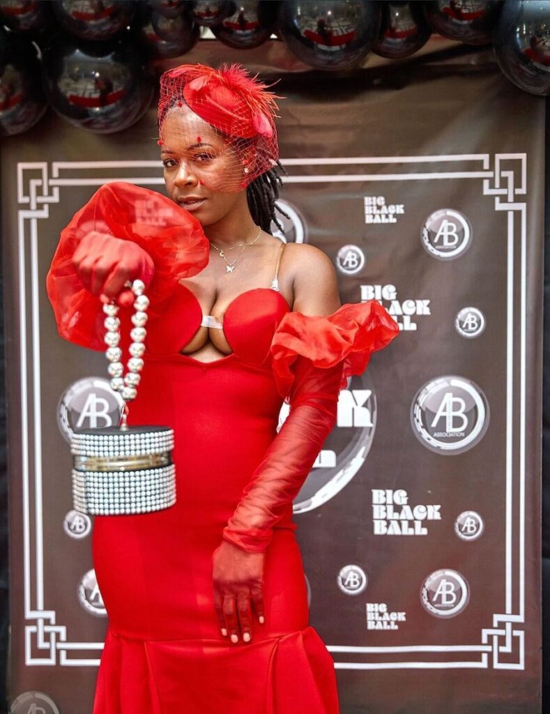 A woman wears a fancy red dress at a red carpet event