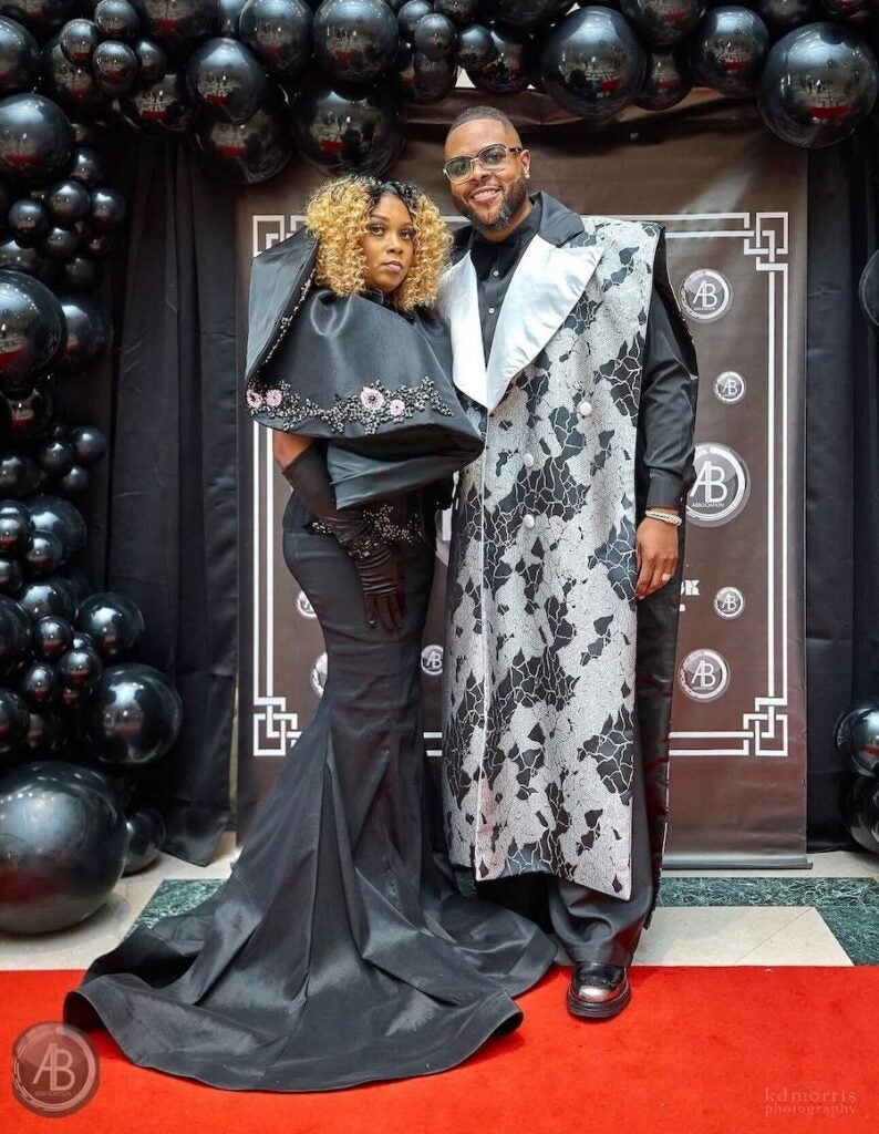 A man and woman in fancy clothes at a red carpet event