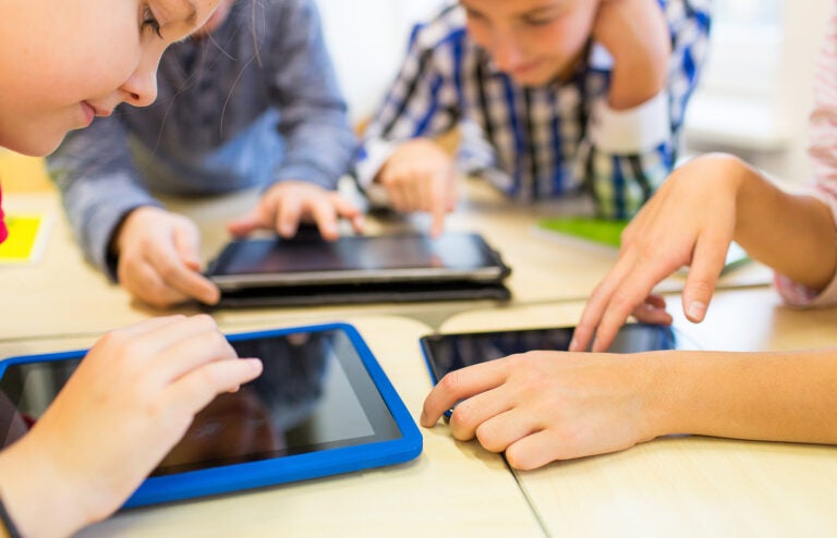 education, elementary school, learning, technology and people co education, elementary school, learning, technology and people concept - close up of school kids with tablet pc computers having fun and playing on break in classroom
