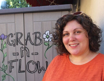 Shelley Aragoncillo poses for a picture alongside the original Grab n' Flow shed in South Philadelphia