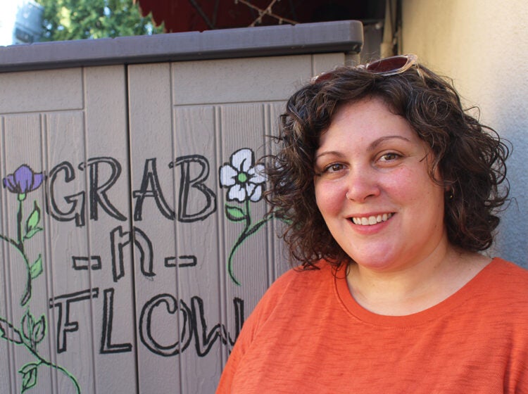 Shelley Aragoncillo poses for a picture alongside the original Grab n' Flow shed in South Philadelphia