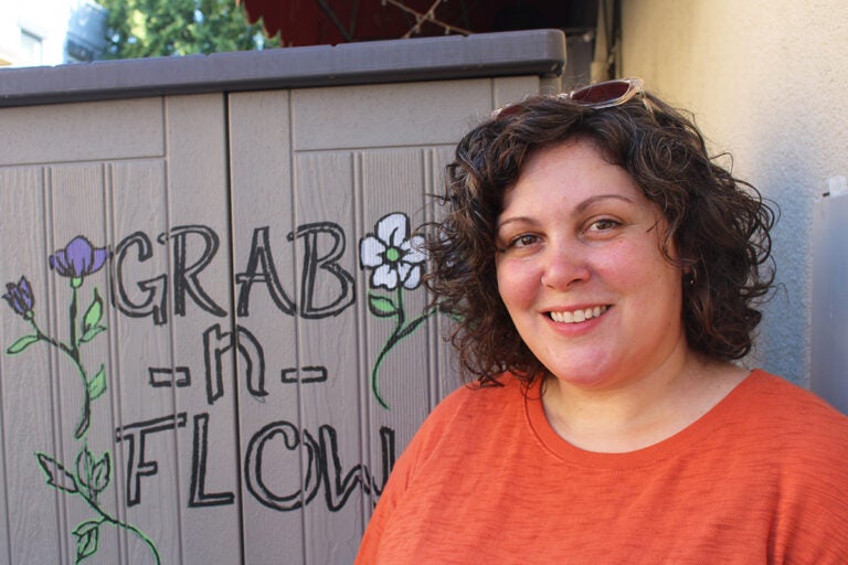 Shelley Aragoncillo poses for a picture alongside the original Grab n' Flow shed in South Philadelphia