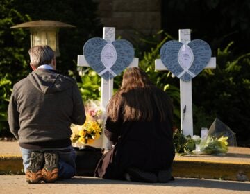 Two people praying at a memorial for slain kids in a Minneapolis school shooting