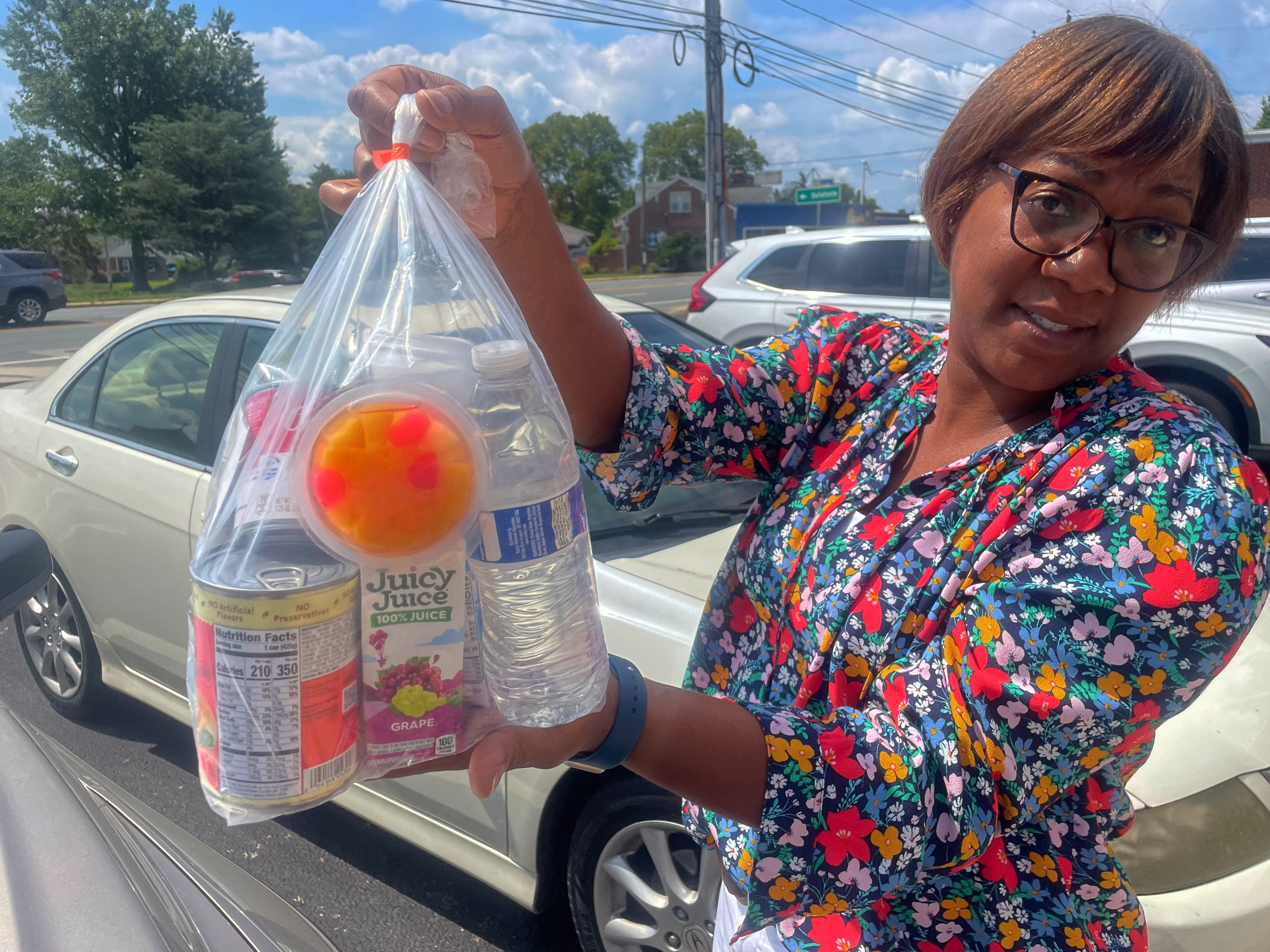 Tiffany Johnson holding food packs created for clients