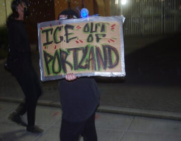 A man holds up a sign that reads 