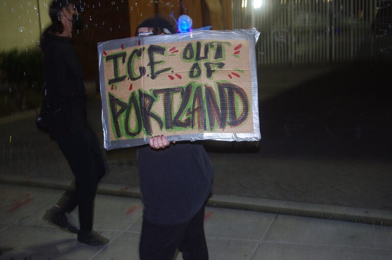 npr_immigration_arrests copy A man holds up a sign that reads